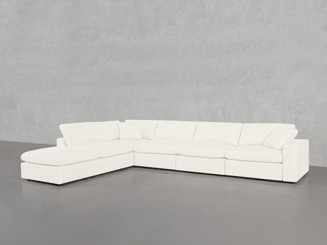 A spacious white 6-Seat Modular Corner Lounger Sectional with plush cushions is placed against a plain light gray textured wall and gray floor.
