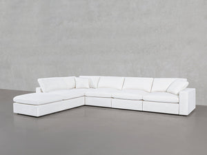 The 6-Seat Modular Corner Lounger Sectional, in modern white, features a left-side chaise and sits against a plain light gray wall and floor.