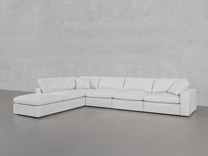 The 6-Seat Modular Corner Lounger Sectional, featuring a modern design in light gray with plush cushions and clean lines, sits on a smooth gray floor against a lightly textured wall.