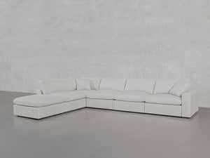 A spacious, modern 6-Seat Modular Corner Lounger Sectional in light gray with plush cushions and a left-side chaise is set against smooth, light-colored walls and flooring.