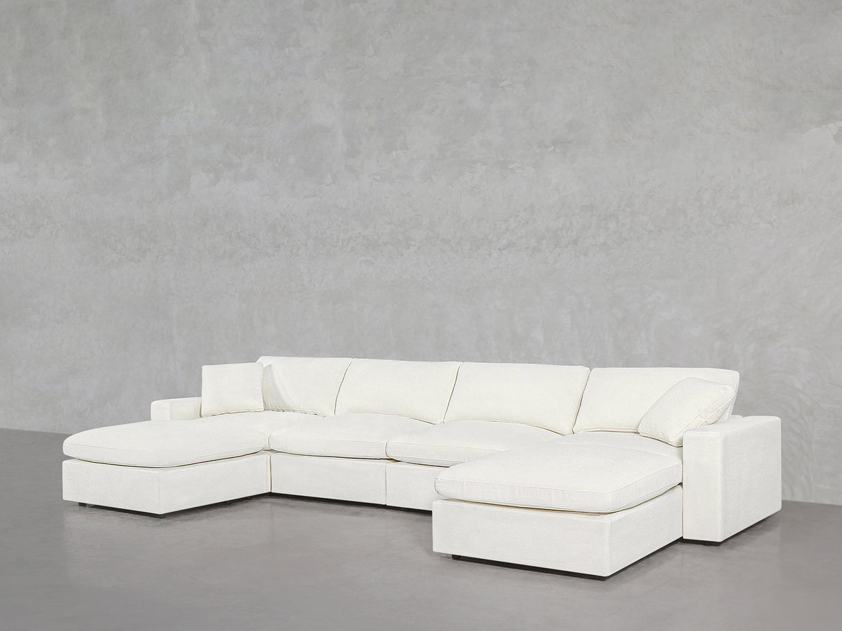 A 6-Seat Modular Double Chaise Sectional in modern white is positioned against a plain, light gray textured wall in a minimalist space.