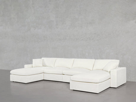 A 6-Seat Modular Double Chaise Sectional in modern white is positioned against a plain, light gray textured wall in a minimalist space.