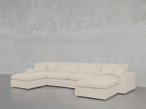 The 6-Seat Modular Double Chaise Sectional, featuring clean lines and plush cushions in light beige, is set against a gray textured wall and floor, with a chaise lounge on each end for modern comfort.