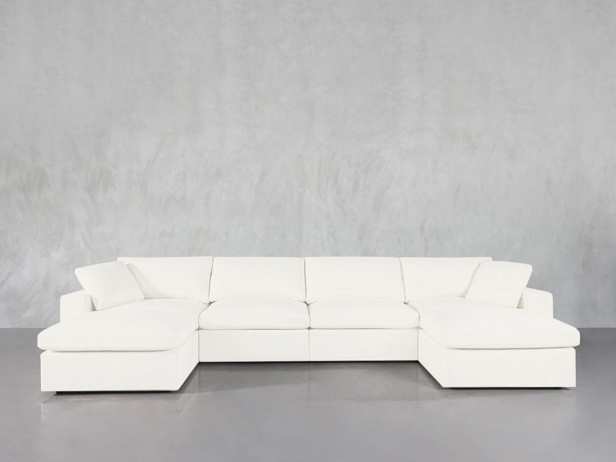 The 6-Seat Modular Double Chaise Sectional features wide armrests and plush cushions, showcased in modern white against a light gray wall and gray floor.