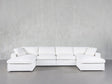 The 6-Seat Modular Double Chaise Sectional, featuring a modern design with clean lines and plush cushions, is placed on a smooth gray floor against a light gray textured wall.