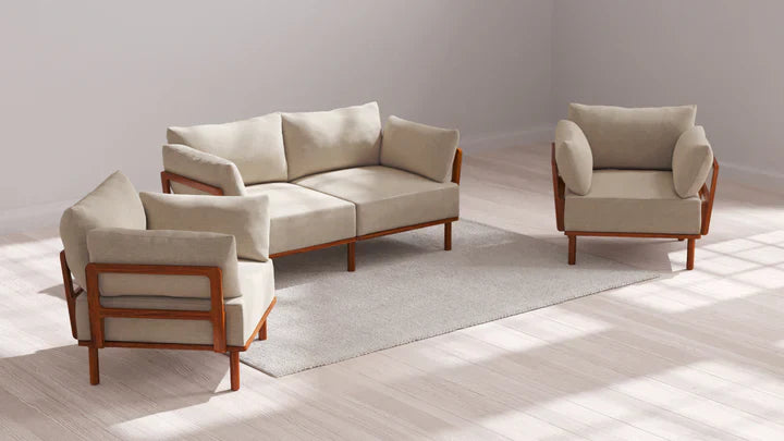 A minimalist living room setup featuring the Indoor Jack 2-Seater Sofa + Armchair Set in Balsa is complemented by two matching armchairs on a light gray rug. The furniture boasts elegant wooden frames and cushions, perfectly situated against a light wooden floor bathed in natural lighting.