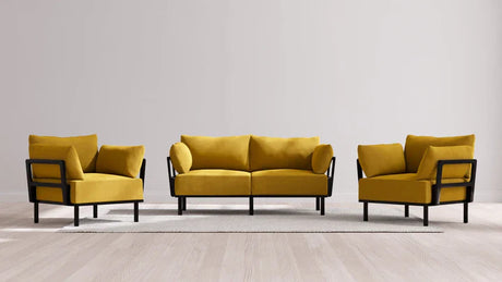 Presenting the Indoor Jack 2-Seater Sofa + Armchair Set in Balsa, a contemporary living room ensemble showcasing a vibrant mustard yellow sofa paired with two matching armchairs set in sleek black frames. This stylish furniture set is artfully arranged on a light gray rug atop a light wood floor, all against a neutral beige wall backdrop.
