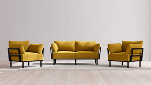 Presenting the Indoor Jack 2-Seater Sofa + Armchair Set in Balsa, a contemporary living room ensemble showcasing a vibrant mustard yellow sofa paired with two matching armchairs set in sleek black frames. This stylish furniture set is artfully arranged on a light gray rug atop a light wood floor, all against a neutral beige wall backdrop.