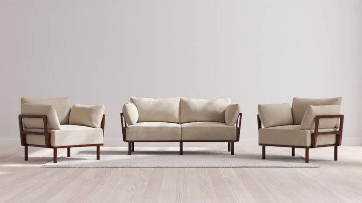 A minimalist living room setup featuring an Indoor Jack 2-Seater Sofa and Armchair Set in Balsa, arranged on a light-colored area rug against a plain white wall.