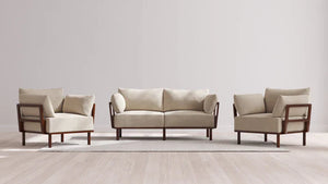 A minimalist living room setup featuring an Indoor Jack 2-Seater Sofa and Armchair Set in Balsa, arranged on a light-colored area rug against a plain white wall.