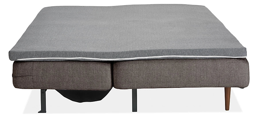 Introducing the Deco Convertible Sleeper Sofa: a sleek, minimalist gray sofa bed featuring a compact dual-cushion design with slender legs, ideal for small spaces. The mattress is elegantly wrapped in matching gray fabric.
