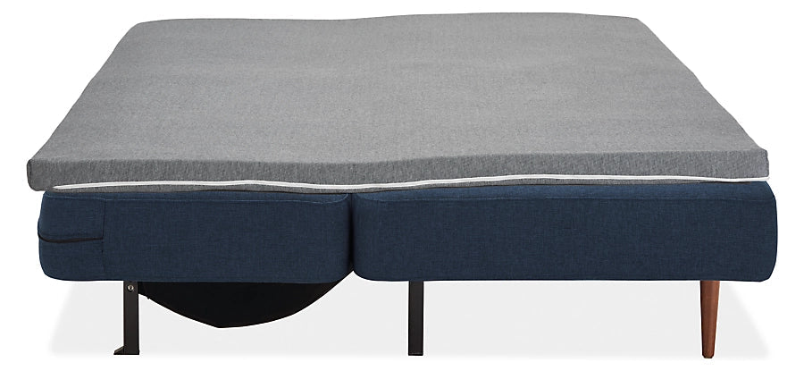Introducing the Deco Convertible Sleeper Sofa: a contemporary blue sofa bed equipped with a light gray mattress topper. It features an easy folding mechanism that transforms it into a flat sleeping position, supported by sleek black metal and wooden legs.