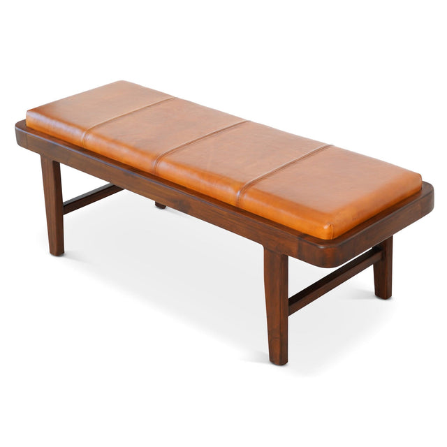 The Maddox Bench features a rustic rectangular design with a tan leather cushioned top, divided into three sections. It boasts four sturdy legs and a dark finish for a simple yet elegant look.