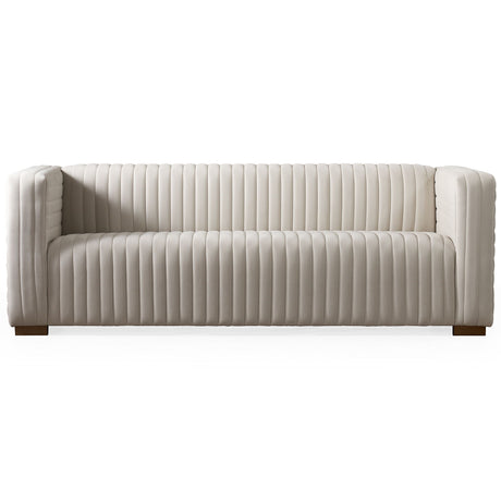 The Elara Upholstered Sofa features a modern white design with vertical tufted lines, wooden legs, straight arms, and backrest. Its low-profile build offers a sleek look perfect for a contemporary living room.