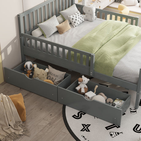 A children's bedroom features a gray Platform Bed with Guardrails on Both Sides and 2 Storage Drawers, one containing toys and stuffed animals. The bed is dressed in a green blanket with decorative pillows, while a round rug with playful letters adorns the wooden floor.