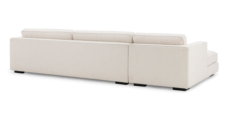 The Architect 133" Fabric Sofa Sectional Left in Blanc Boucle is depicted from a rear view, showcasing its cream-colored, rectangular silhouette with three cushioned backrests. Its minimalist design is complemented by sleek black square legs against a plain white backdrop.