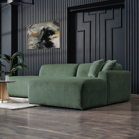 A modern living room features the Mar High-Quality Sectional Sofa in green on polished wooden floors, complemented by a plant and an abstract painting on a dark-textured wall, crafting a stylish and cozy atmosphere.