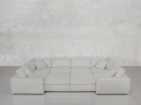 The 8-Seat Modular Closed Pit, in light gray with four matching cushions, is arranged against a plain textured light gray wall and a smooth gray floor.