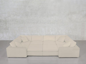 An 8-Seat Modular Closed Pit in beige, paired with four matching cushions, is arranged in a U-shape against a light gray textured wall and concrete floor.