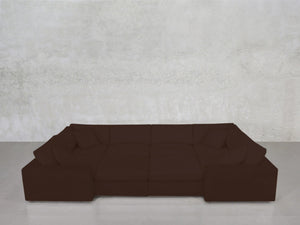 An 8-Seat Modular Closed Pit in dark brown with wide armrests and four matching cushions is set against a textured light gray wall on a smooth gray floor.