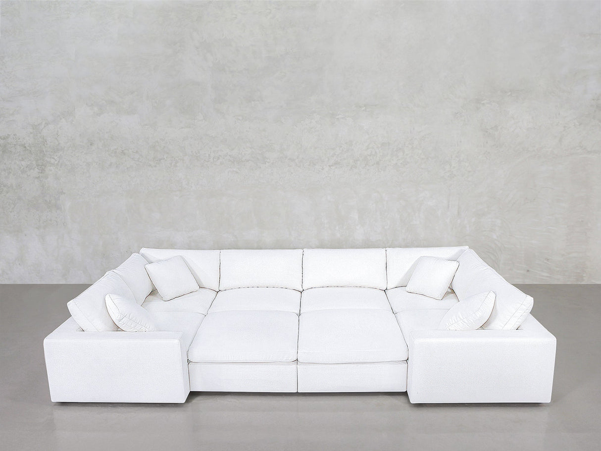 An 8-Seat Modular Closed Pit sectional in modern white, with four matching cushions, set against a light gray wall and polished concrete floor.