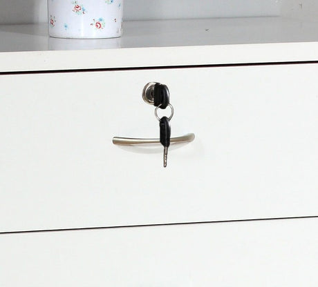 A 5 Drawer Chest in white with metal handles features a locking top drawer with a key inserted. A white container with a floral design is partially visible on the shelf above.