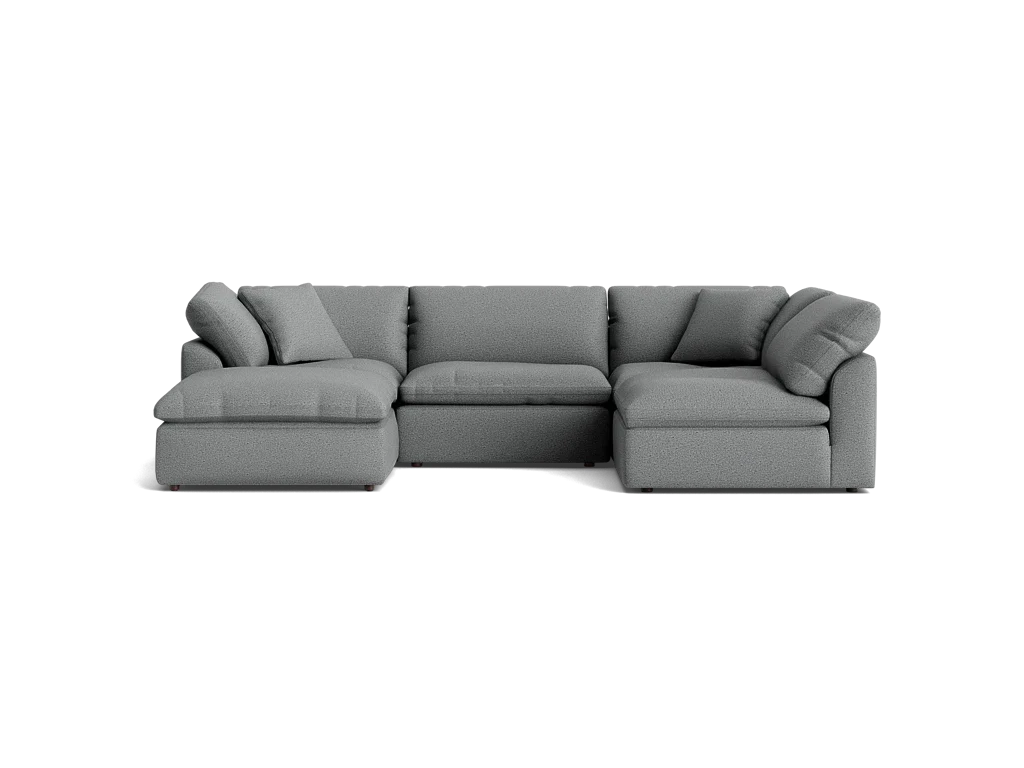 A stylish Bryant U-Sofa Bumper Sectional in gray, featuring plush cushions and a left-hand chaise, set against a solid black background.