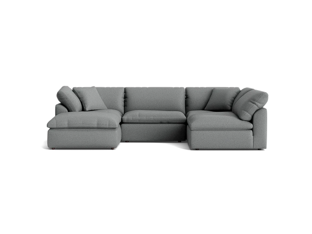 A stylish Bryant U-Sofa Bumper Sectional in gray, featuring plush cushions and a left-hand chaise, set against a solid black background.