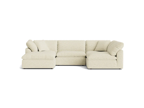 The Bryant U-Sofa Bumper Sectional, a beige L-shaped sofa with cushioned seats and backrests, is placed against a plain black background. This inviting and comfortable design is ideal for a modern living room.