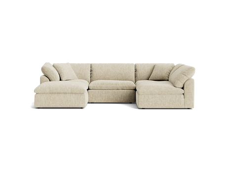 A Bryant U-Sofa Bumper Sectional in beige, featuring an L-shaped design with a chaise on the left side, plush cushions, and a low-profile style, set against a plain black background.