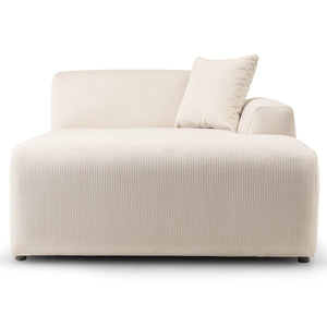 The Mar High-Quality Sectional Sofa is a modern white chaise lounge with a ribbed texture, featuring a left armrest and matching pillow. Its minimalist and elegant design is subtly elevated by small black legs.
