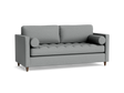 The Briar Sleeper Sofa, a contemporary gray fabric piece featuring two back cushions, two bolster pillows, and wooden legs against a black background, showcases a textured, tufted seat design.
