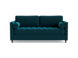 The Briar Sleeper Sofa is showcased against a plain black background, featuring button-tufted cushions and cylindrical armrests in a dark teal color. It boasts wooden legs and a modern design.