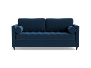 The Briar Sleeper Sofa is a dark blue piece featuring tufted cushions and two round bolster pillows, designed in a modern style with wooden legs that give it a clean, sleek appearance against a black background.