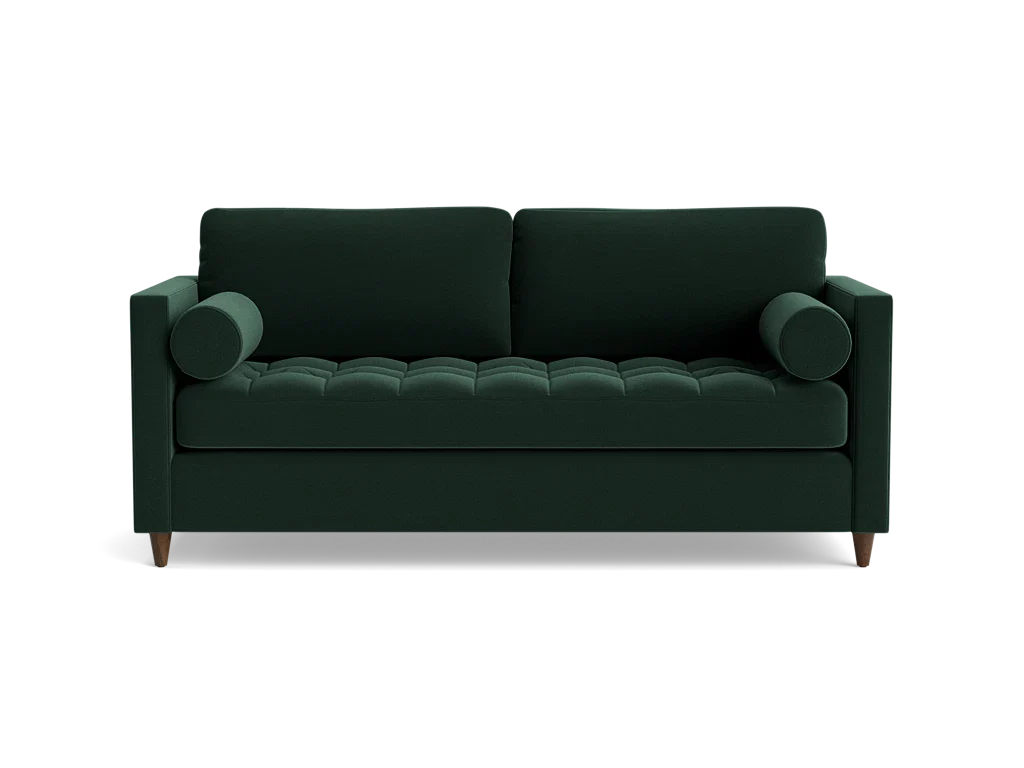 The Briar Sleeper Sofa is a dark green, mid-century modern piece featuring two cylindrical arm cushions and tufted seating. It is elevated on short wooden legs and presented against a plain black background.