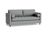The Briar Sleeper Sofa, a contemporary gray fabric piece featuring two back cushions, two bolster pillows, and wooden legs against a black background, showcases a textured, tufted seat design.