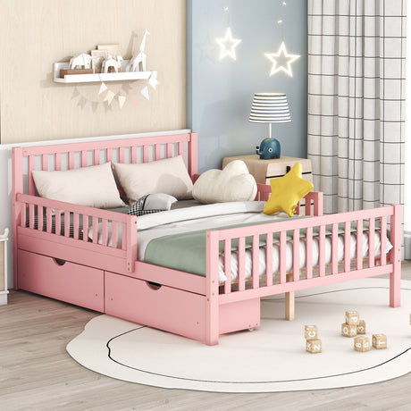 A children's bedroom has a pink platform bed with side guardrails and two storage drawers, white bedding, stuffed toys including a star-shaped pillow, hanging star lights, a table lamp, a bookshelf filled with books, and wooden blocks scattered on a round rug.