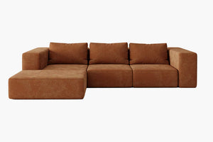 The Atlas Modular Sofa by Acanva is a large brown sectional with a modern, minimalist design, featuring three back cushions and an extended chaise lounge on the left side against a white background.