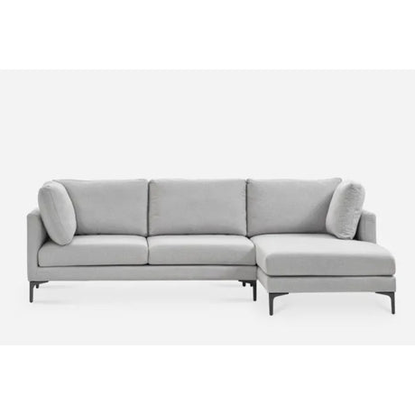 A modern L-shaped light gray sectional sofa with three seat cushions, an attached chaise on the right side, and two cylindrical throw pillows. The sofa has a minimalist design with slender black legs, set against a plain white background.
