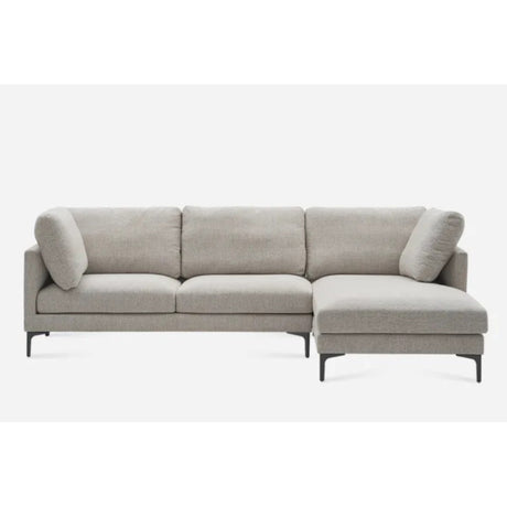 A modern gray sectional sofa with a chaise lounge on the right side. It has minimalist design and clean lines, featuring plush cushions and black legs, set against a plain white background.