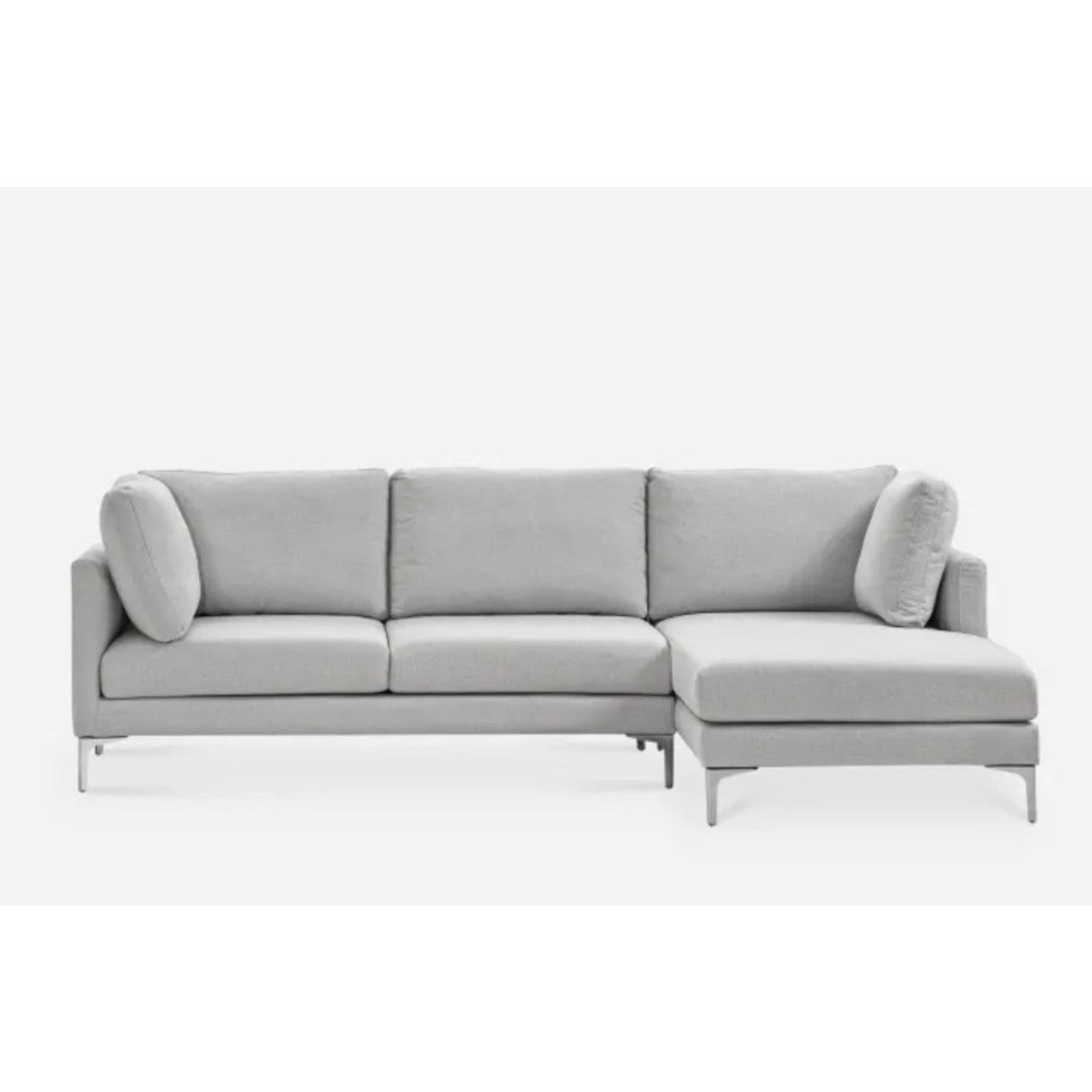 A modern, light gray sectional sofa with three cushioned seats and a right-side chaise lounge. It features metal legs and comes with matching side pillows, set against a plain white background.