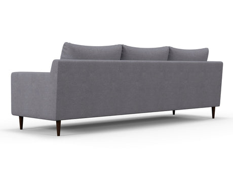 The Alex Sofa is a contemporary piece with a minimalist design, featuring three cushions and a low backrest. It stands on dark, tapered wooden legs, presenting a sleek modern look when viewed from the back at an angle.
