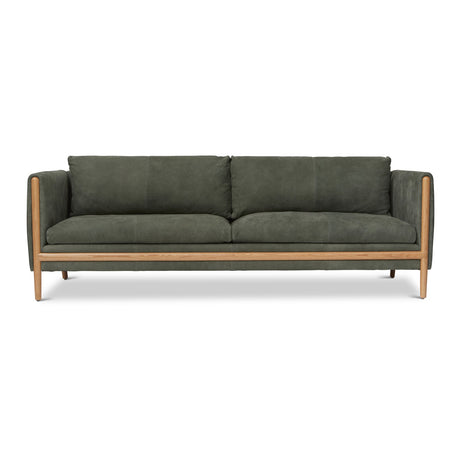 Introducing the Bungalow Leather Sofa in Verde: a contemporary green masterpiece featuring a sleek and minimalist design. It boasts plush leather cushions with two generous seat cushions, two comfortable back cushions, and elegant wooden legs and accents.