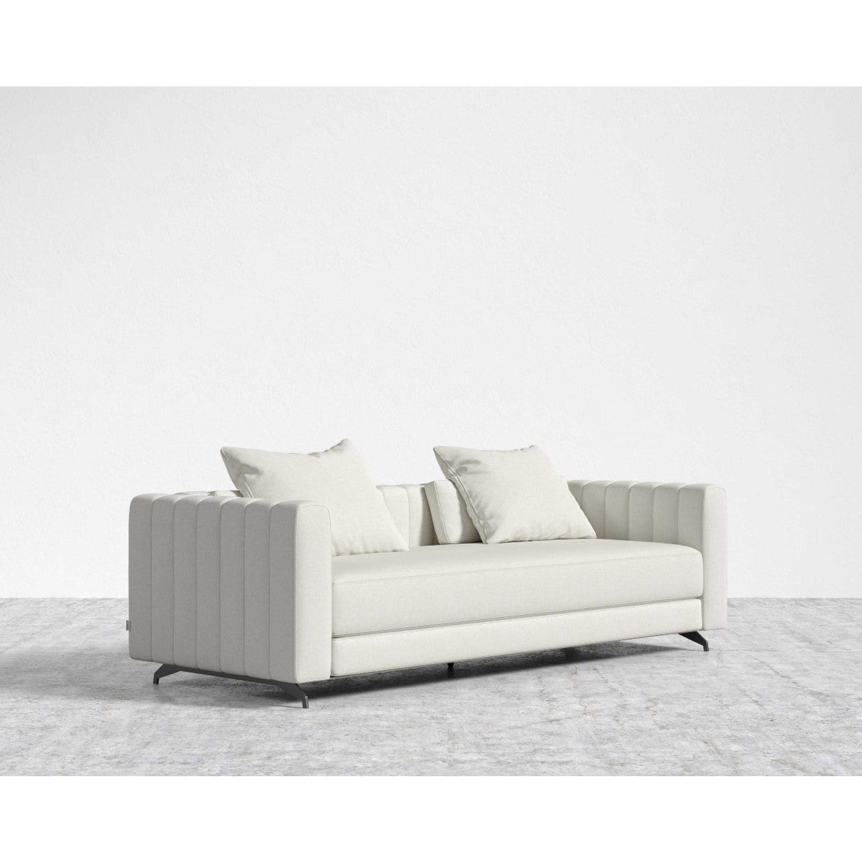 The Berlin Sleeper Sofa, with its modern light gray upholstery and vertically tufted sides and arms, is elegantly positioned on a textured gray rug. It includes two matching throw pillows and stands on sleek black legs, all set against a plain white background.