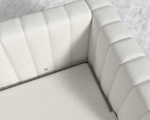 Top view of the Berlin Sleeper Sofa in light gray, featuring modern upholstery. The cushions display vertical stitching and the fabric looks smooth and soft. It is set on a light-colored textured floor.