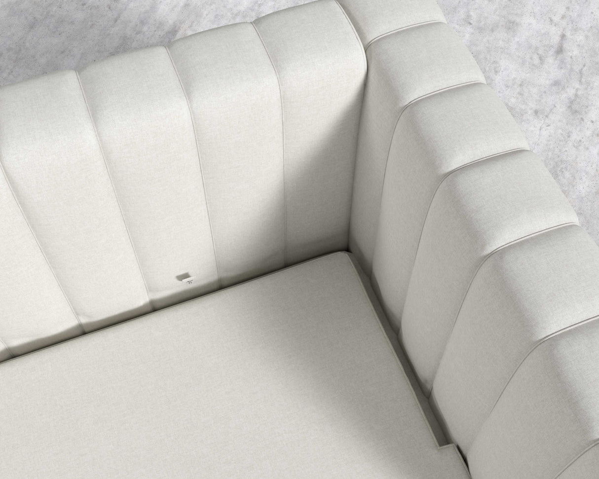 Top view of the Berlin Sleeper Sofa in light gray, featuring modern upholstery. The cushions display vertical stitching and the fabric looks smooth and soft. It is set on a light-colored textured floor.