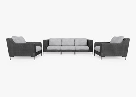 The Black Wicker Outdoor Sofa with Armchairs - Five Seat set offers a contemporary design, showcasing a three-seater sofa and two matching armchairs. These pieces feature sleek dark wicker frames paired with light gray cushions, all set against a pristine white background.
