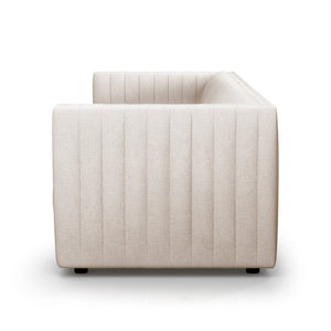Side view of the Brandt 97'' Upholstered Sofa, showcasing its modern beige appearance and minimalist design. The upholstery is highlighted by vertical stitching, while it rests on small, dark legs against a plain white background to accentuate its clean lines.