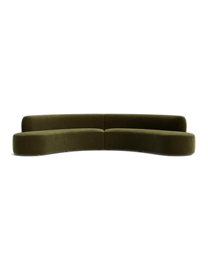 A sleek, modern Cara Sectional Sofa in dark green velvet with a curved design is set against a plain black background. The sofa features a minimalist style with no visible legs and a smooth, continuous backrest.