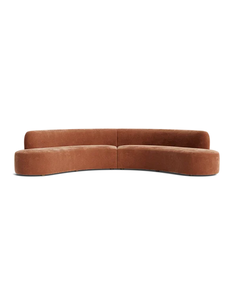 The Cara Sectional Sofa, featuring a brown curved design, sits against a black background with its modern simplicity and hidden legs.